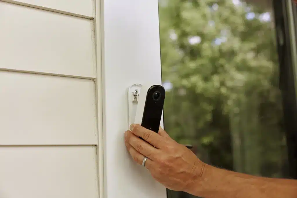 Hand holding Arlo doorbell